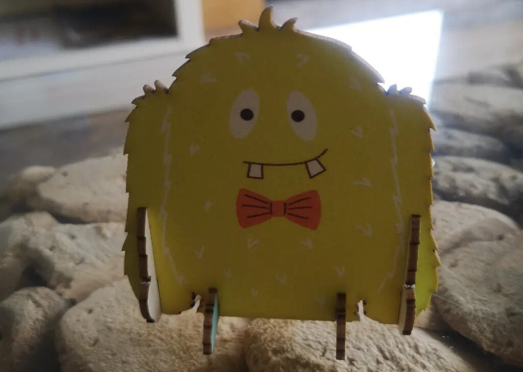Yellow monster birthday card. The monster is yellow and wearing a red bow tie. He appears to have a couple of teeth missing.